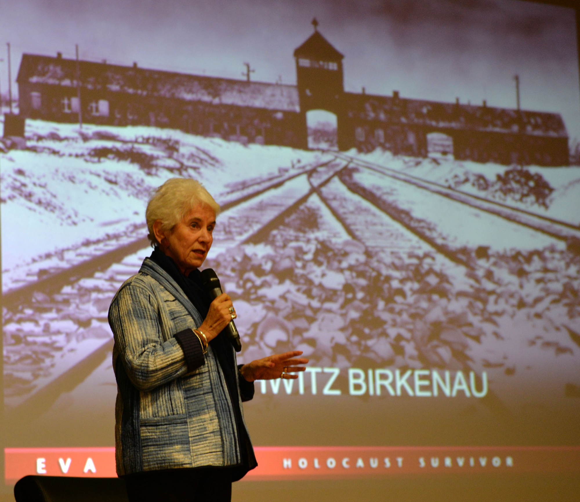 Eva Clarke, Holocaust survivor, talks about how her mother, father, and other family members – along with thousands of others – were kept imprisoned at Auschwitz-Birkenau and other concentration camps by the Germans during World War II, at a Storytellers event at RAF Mildenhall, England, April 26, 2018. Clark travels the country to share her mother’s story and raise awareness about the Holocaust, remember those who died, and help others learn the lessons of the Holocaust to help counteract any form of racism or prejudice. (U.S. Air Force photo by Karen Abeyasekere)