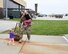 An Airman picks up his two daughters while a line of returning Airmen approach behind him.