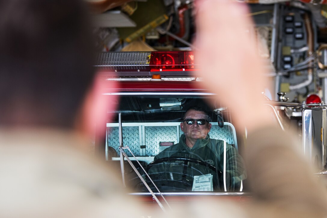 A senior airman gives a master sergeant driving instructions for loading a C-17 Globemaster III.