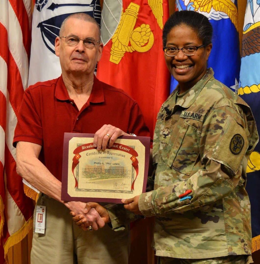 Army Col. Traci Crawford, Brooke Army Medical Center deputy commanding officer, poses for a photo with Phil Lewis, BAMC Department of Ministry and Pastoral Care Volunteer of the Year, during the BAMC Volunteer Recognition Ceremony April 16.