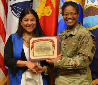 Army Col. Traci Crawford, Brooke Army Medical Center deputy commanding officer, poses for a photo with Sandy Montelongo, BAMC Office of Volunteer Services Volunteer of the Year, during the BAMC Volunteer Recognition Ceremony April 16.