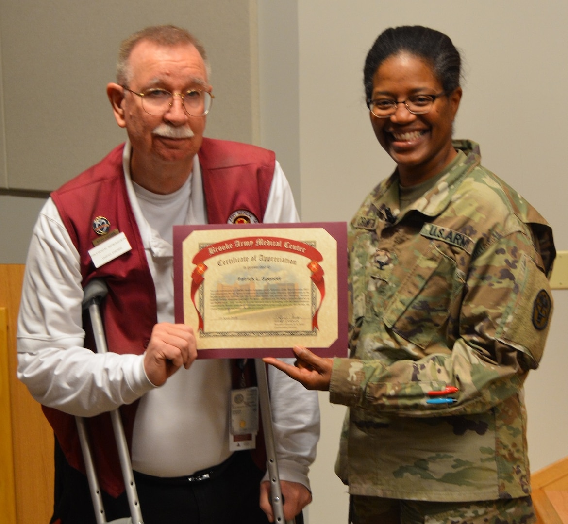 Army Col. Traci Crawford, Brooke Army Medical Center deputy commanding officer, poses for a photo with Patrick Spencer, BAMC Retiree Activities Group Volunteer of the Year, during the BAMC Volunteer Recognition Ceremony April 16.