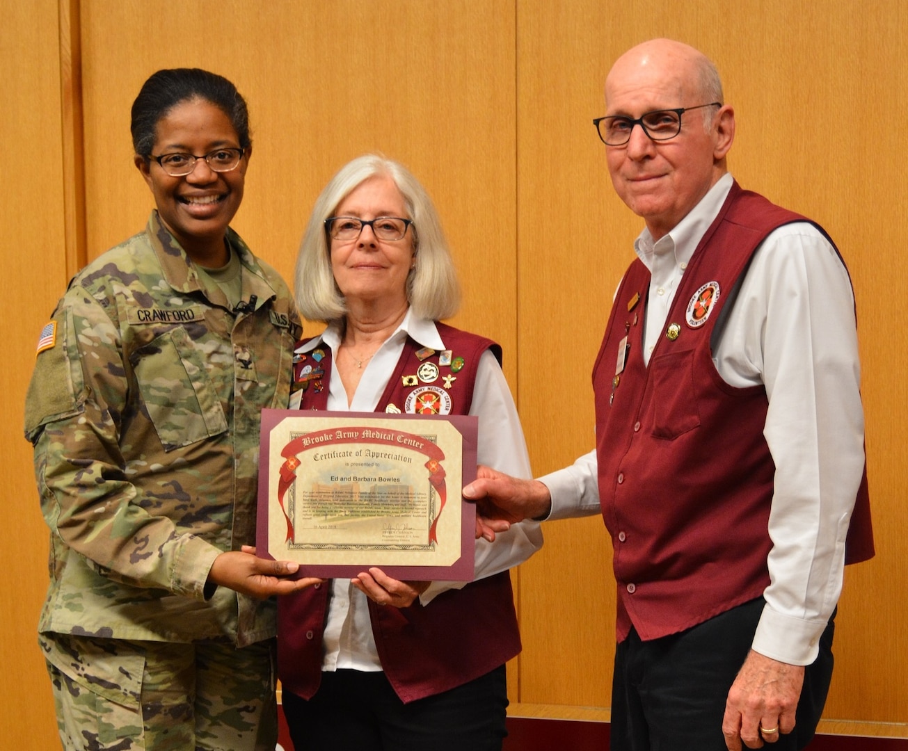 Army Col. Traci Crawford, Brooke Army Medical Center deputy commanding officer, poses for a photo with Barbara and Ed Bowles, BAMC Family of the Year, during the BAMC Volunteer Recognition Ceremony April 16.