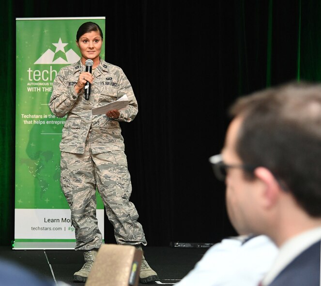 Dr. William Roper, assistant secretary of the Air Force for Acquisition, Technology and Logistics, looks on as Capt. Austin Delorme, addresses attendees at the TechStars Autonomous Technology Accelerator for the Air Force Demo Day at the Westin Hotel in Boston, April 20.