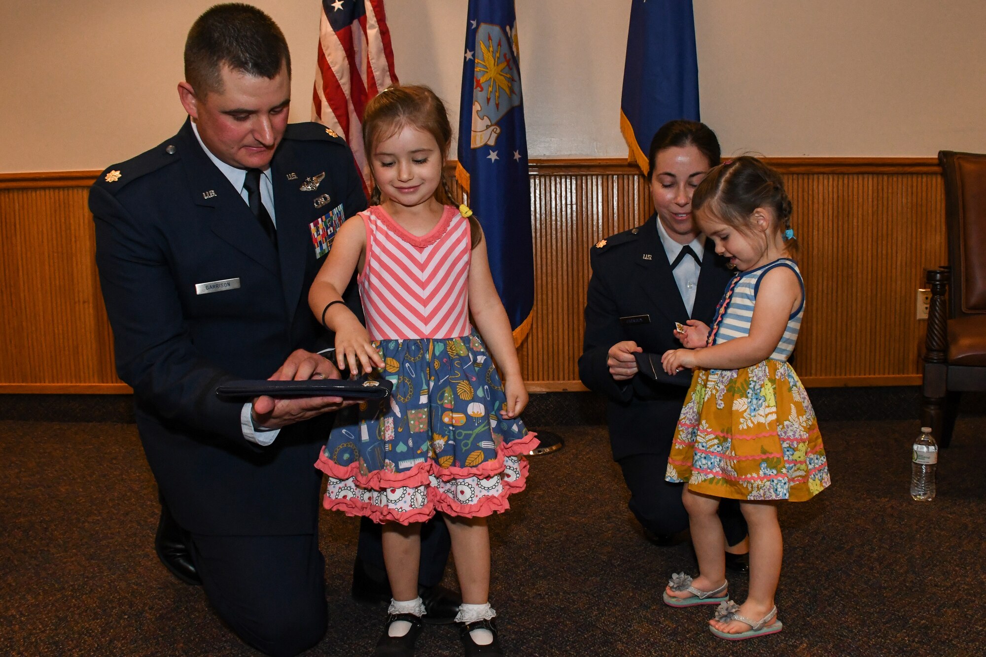 A family affair. Lt. Cols. Shane and Jennifer Garrison receive help from their children during a shared promotion ceremony at Barksdale Air Force Base, La., April 20, 2018.