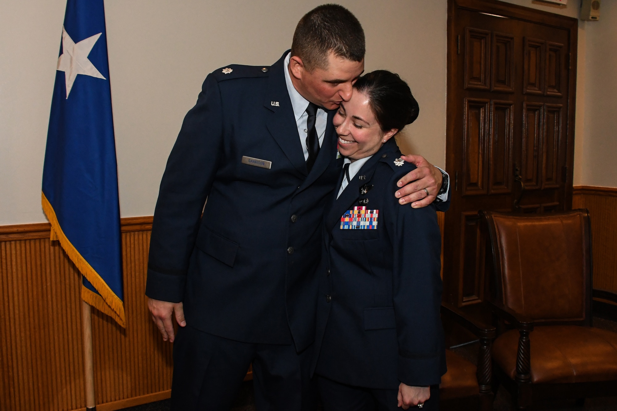 Eighth Air Force husband and wife team, Lt. Cols. Shane and Jennifer Garrison, show a little affection during a shared promotion ceremony at Barksdale Air Force Base, La., April 20, 2018.