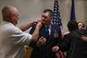 The parents of Lt. Col. Shane Garrison "pin on" and congratulate the husband and wife team during a shared promotion ceremony at Barksdale Air Force Base, La., April 20.