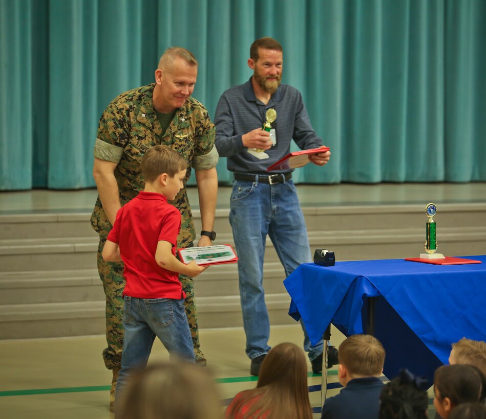 Lt. Col. Matthew Stover hands out awards to students during the Earth Day poster award ceremony aboard Laurel Bay April 24. Children from Charles F. Bolden Elementary School and Elliott Elementary School competed in the poster contest as a way to educate and involve children on environmental management. This year�s theme for the contest was �Give a hoot, Don�t Pollute.� April 22 has been designated as Earth Day since 1970 and Across the Marine Corps, installations are participating in Earth Day activities to help remind all Marines, Sailors, civilians, and their families that their everyday actions help protect our resources and contribute to the long-term success of the Marine Corps. Stover is the executive officer of Marine Corps Air Station Beaufort.