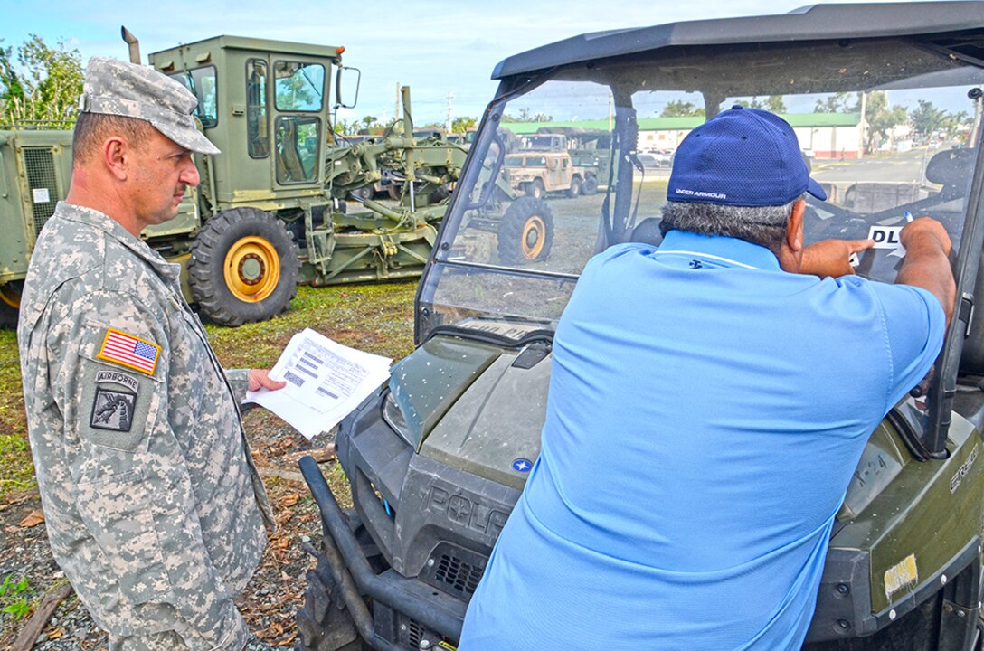 DLA Disposition Services' Luis Pena signs the paperwork and affixes the sticker that makes it official: this utility vehicle is no longer the responsibility of the U.S. National Guard. The Defense Logistics Agency will offer it to other military units, and if no one requisitions it, will then offer it to a variety of other qualified customers or sell it.