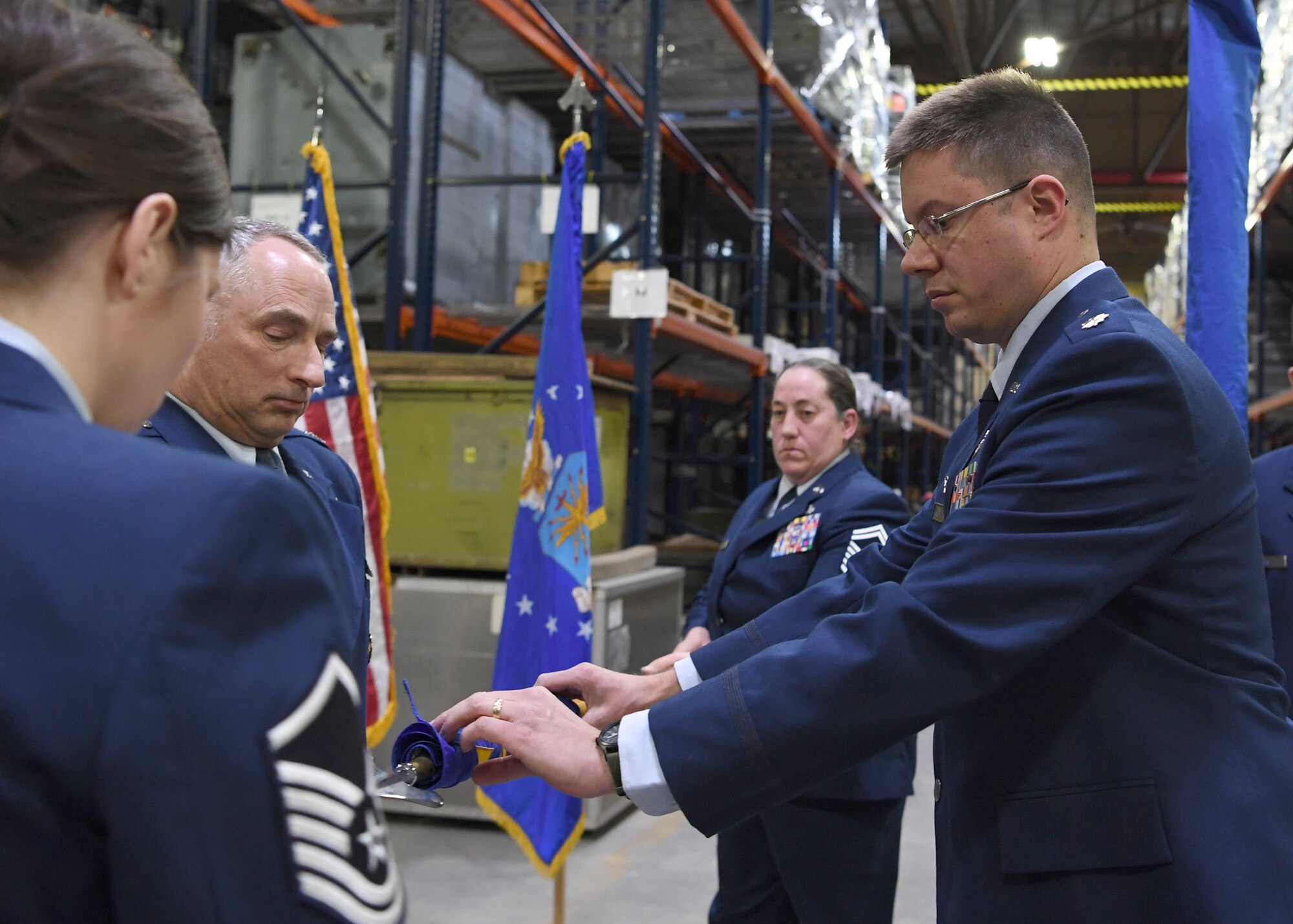 Lt. Col. Christopher Beckley, 49th Aerial Port Squadron commander, right, folds the 49th Aerial Port Flight Flag as part of the deactivation portion of the 49th APS re-designation ceremony, as Col. Scott Russell, 434th Mission Support Group and presiding officer, looks on. Master Sgt. Shannon Fuller, 49th APS first sergeant and proffer, far left, prepares to encase the flag as Senior Master Sgt. Laurie Latchaw, 49th APS senior Air Reserve technician, waits to furl the flag. (U.S. Air Force photo/Staff Sgt. Katrina Heikkinen)