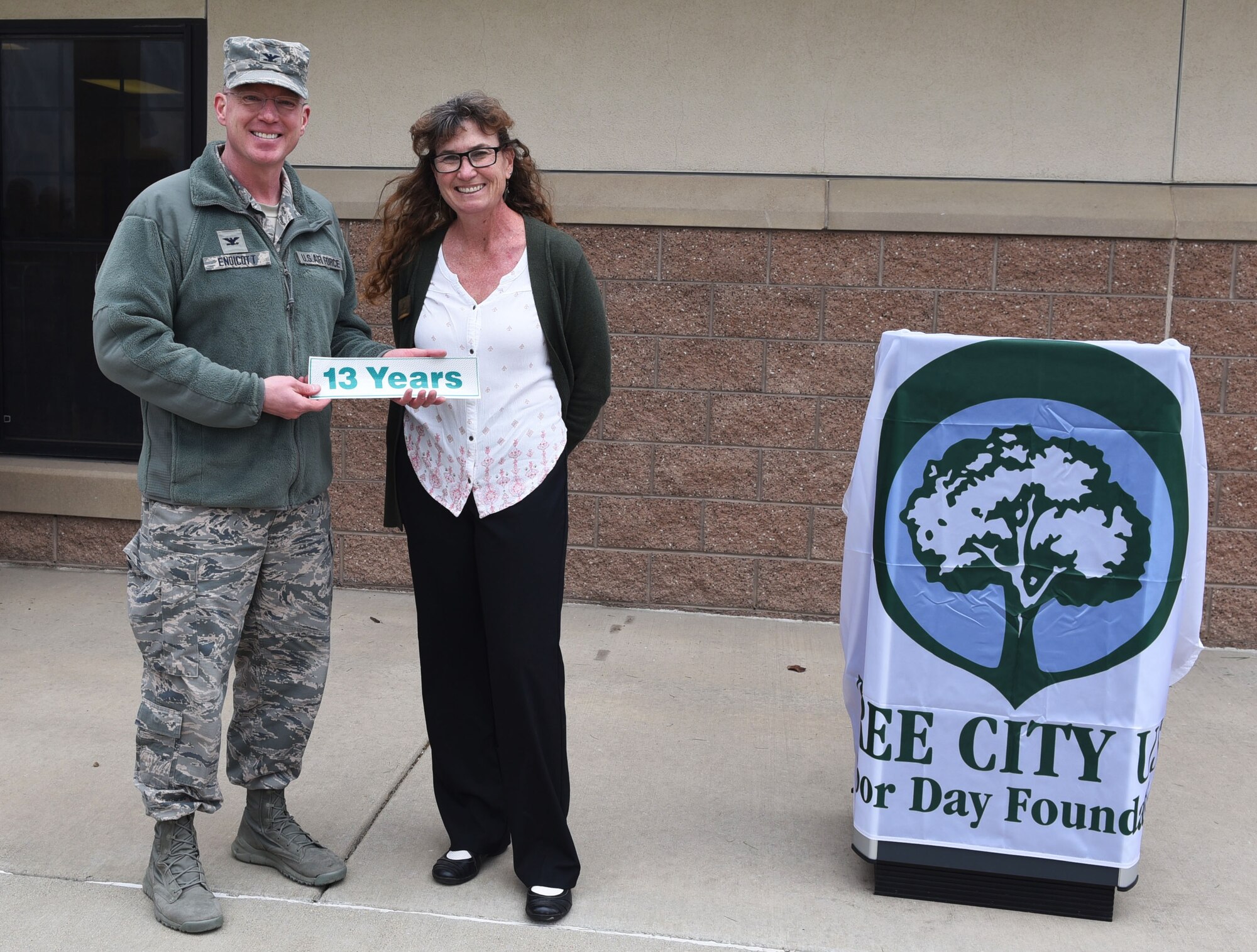 Col. Troy L. Endicott, 460th Space Wing commander, and Ms. Nancy Klasky, a member of the Community Forestry Division for Colorado State, celebrate 13 years Buckley Air Force Base has been a Tree City USA member, April 26, 2018, on Buckley Air Force Base, Colorado. Buckley’s involvement in the Tree City USA program underscores the Air Force’s commitment to landscape beautification and the environment. (U.S. Air Force Photo by Senior Airman Jessica B. Kind)