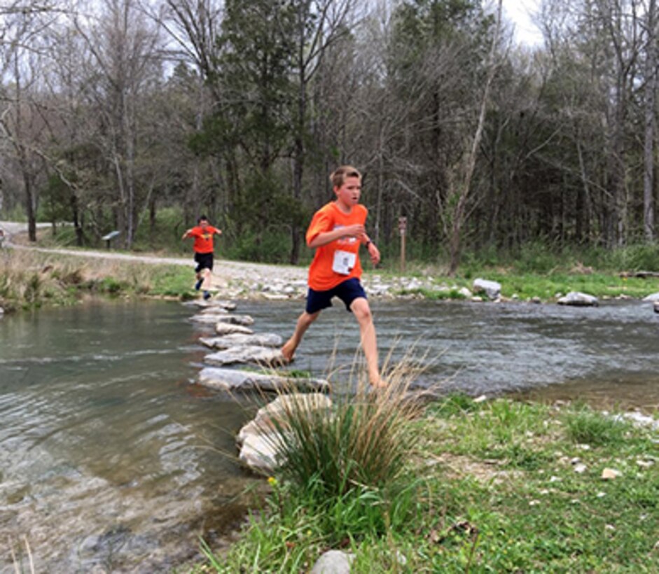 A few young boys run across Hatchery Creek in Jamestown, Ky., during the third annual Trout Trot 5K April 14, 2018 at the Wolf Creek National Fish Hatchery and Kendal Recreation Area below Wolf Creek Dam. The event also kicked off the recreation season at Lake Cumberland, which is operated by the U.S. Army Corps of Engineers Nashville District. (USACE photo by Park Ranger Cody Pyles)