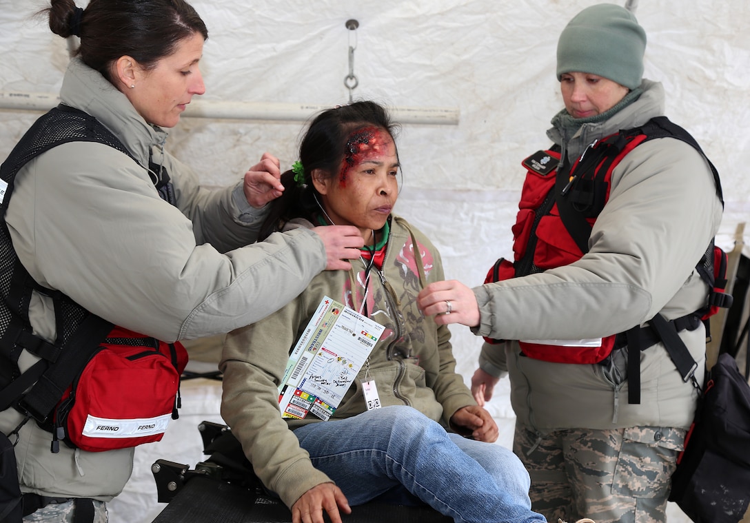 Maj. Tori L. Scearbo, a critical care nurse, and Capt. Kimberly G. Steinhagen, a registered nurse, both  assigned to the 157th Medical Group, N.H. Air National Guard, assess a simulated casualty during a deployment readiness exercise on April 11, 2018 at Joint Base Cape Cod, Mass. Scearbo and Steinhagen participated in a week-long notional training exercise as part of the New England CBRNE Enhanced Response Force Package team. (N.H. Air National Guard photo by Staff Sgt. Kayla White)