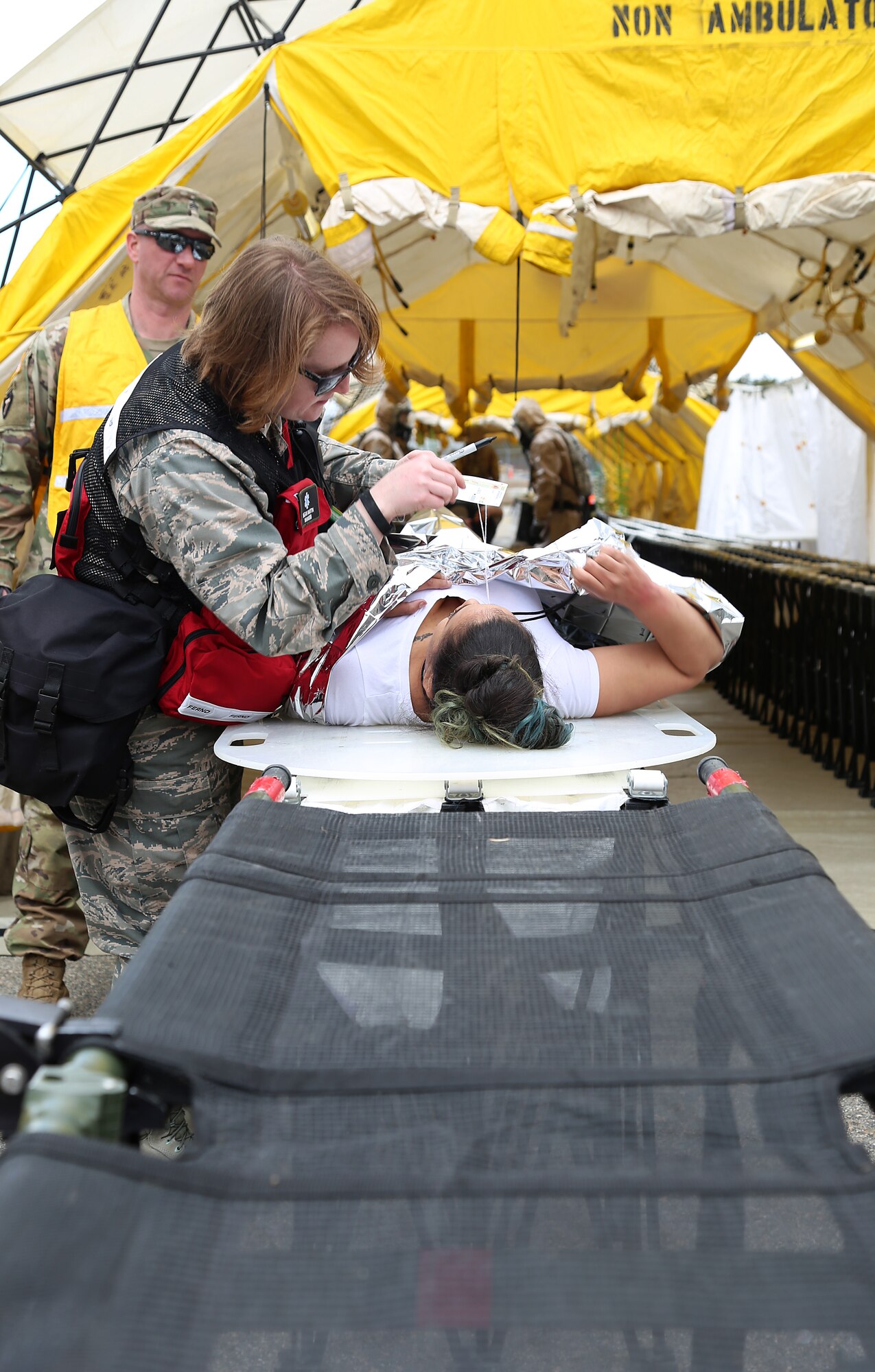 Capt. Megan C. Martin, a nurse assigned to the 157th Medical Group, N.H. Air National Guard, assesses a simulated casualty during a deployment readiness exercise on April 11, 2018 at Joint Base Cape Cod, Mass. Martin is a member of the New England CBRNE Enhanced Response Force Package team. (N.H. Air National Guard photo by Staff Sgt. Kayla White)