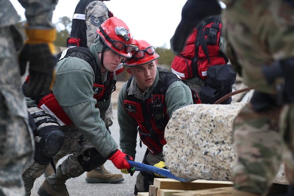 Senior Airman Jesse D. Hyam and Staff Sgt. Alexander J. Barnhart, medical search and extraction team members assigned to the 157th Medical Group, N.H. Air National Guard, work to lift debris during a simulated exercise on April 11, 2018 at Joint Base Cape Cod, Mass. Hyam and Barnhart participated in a weeklong regional deployment readiness exercise as members of the N.H. CBRNE Enhanced Response Force Package team. (N.H. Air National Guard photo by Staff Sgt. Kayla White)