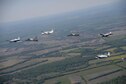 A dissimilar formation of all 14th Flying Training Wing aircraft change their course to fly over the 2018 Wings Over Columbus Open House and Air and Space Show grounds April 20, 2018,  over Columbus, Mississippi. Roughly 21,000 people were able to view hours of aerobatic acts and many static displays from the Air Force’s current inventory at the 2018 air show. (U.S. Air Force photo by Airman 1st Class Keith Holcomb)