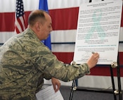 Col. John Edwards, 28th Bomb Wing commander, signs a Sexual Assault Prevention proclamation at Ellsworth Air Force Base, S.D., April 20, 2018. This sexual assault constitution shows that Ellsworth AFB recognizes sexual assault prevention efforts and aids in supporting those affected by it. (U.S. Air Force photo by Airman 1st Class Thomas Karol)