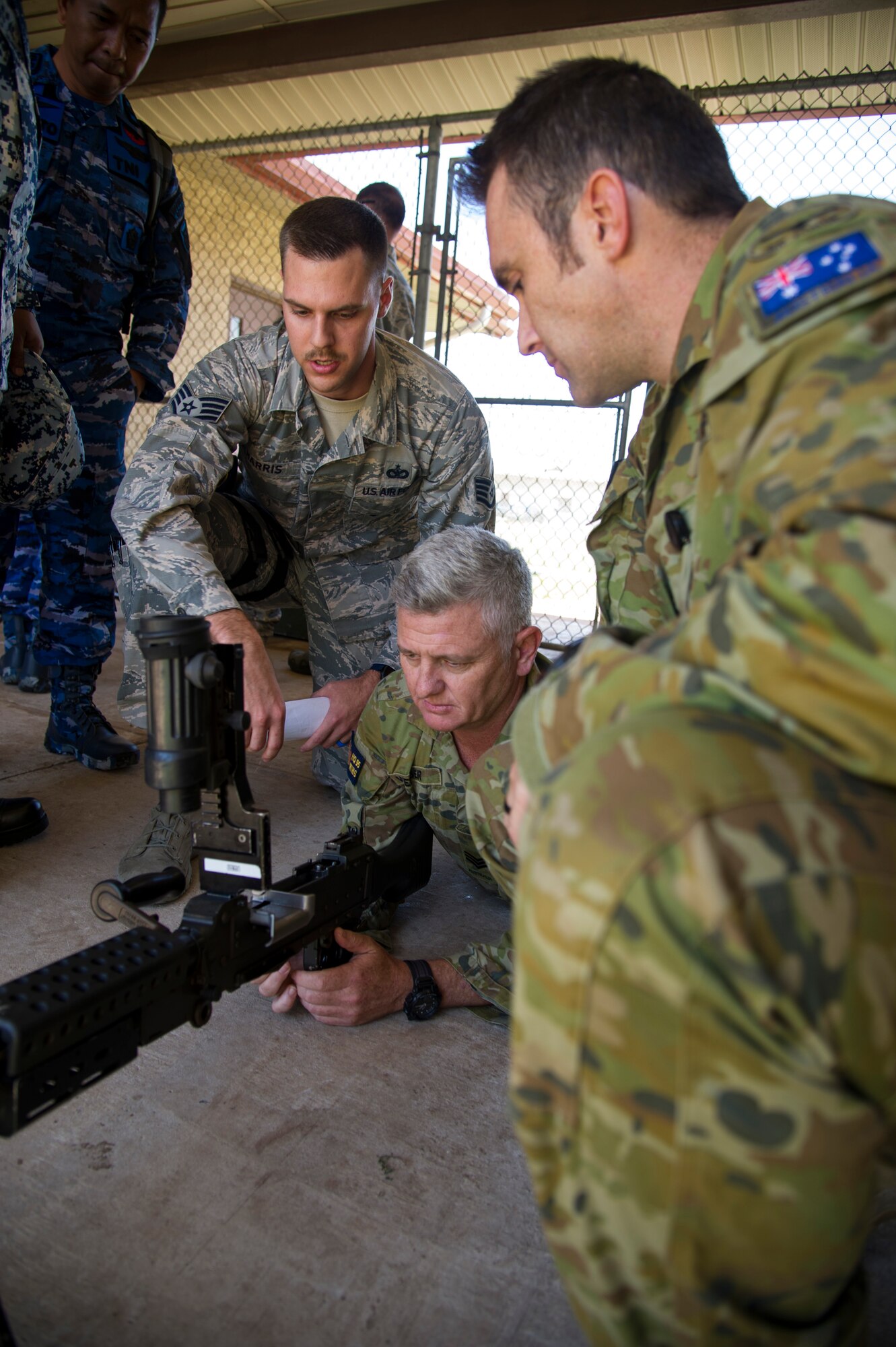 Staff Sgt. Dylan Harris, Joint Base Security combat arms instructor, goes over the capabilities of an M240B machine gun with Sgt. Heath Webber and Squadron Leader Daniel Hamilton, from the Australian Royal Air Force, during a combat arms mission brief for PACIFIC DEFENDER 18-2, Joint Base Pearl Harbor-Hickam, Hawaii, April 10, 2018. PAC DEFENDER 18-2 is a multilateral event intended to enhance strong personal relationships and cooperation with several Asia-Pacific nations.  (U.S. Air Force photo by Tech. Sgt. Heather Redman)