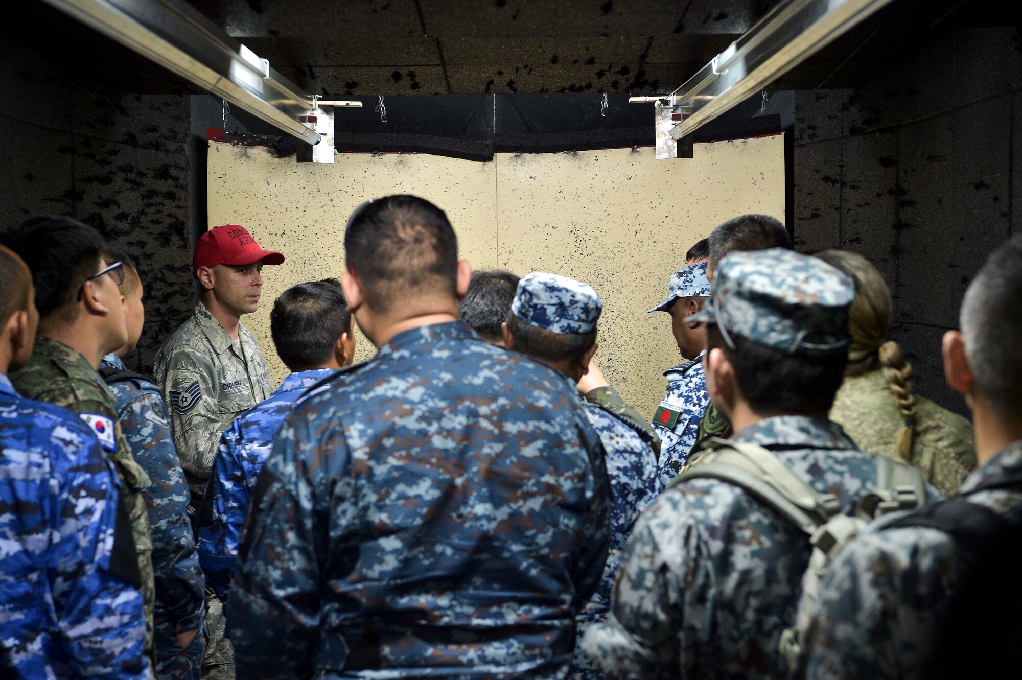 Tech. Sgt. Geoffery Chinen, 154th Security Forces Squadron combat arms instructor, gives PACIFIC DEFENDER 18-2 participants a tour of the 154 SFS indoor shooting range, Joint Base Pearl Harbor-Hickam, Hawaii, April 13, 2018. PAC DEFENDER 18-2 is a multilateral event intended to enhance strong personal relationships and cooperation with several Asia-Pacific nations.  (U.S. Air Force photo by Senior Airman Michael Reeves)