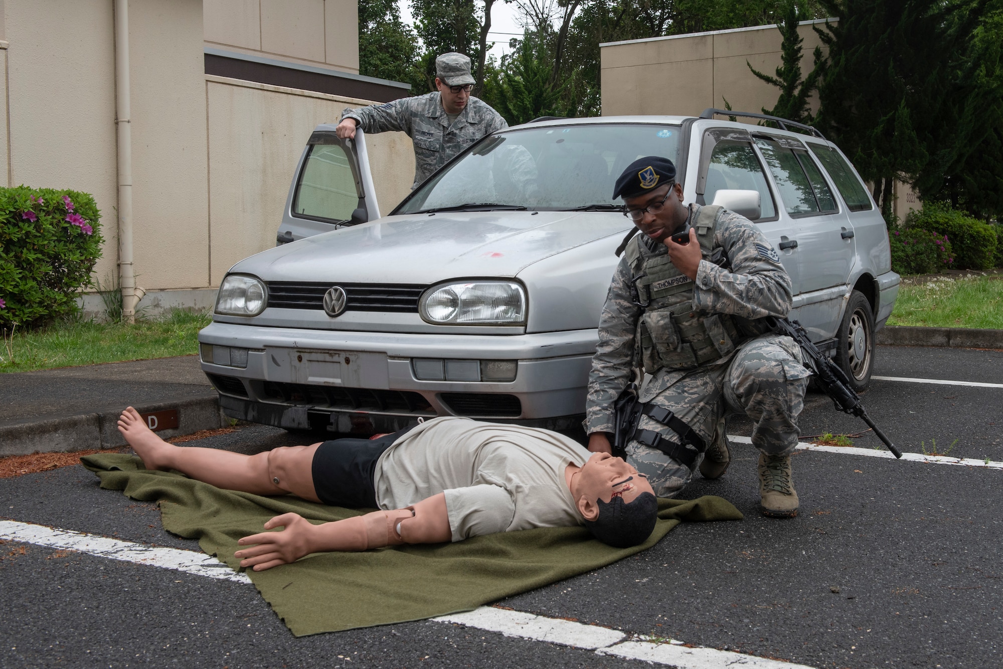 Staff Sgt. Frederick Thompson, 374th Security Forces Squadron patrolman, calls in to dispatch after performing an initial assessment during an inter-agency emergency medical response exercise at Yokota Air Base, Japan, April 24, 2018.