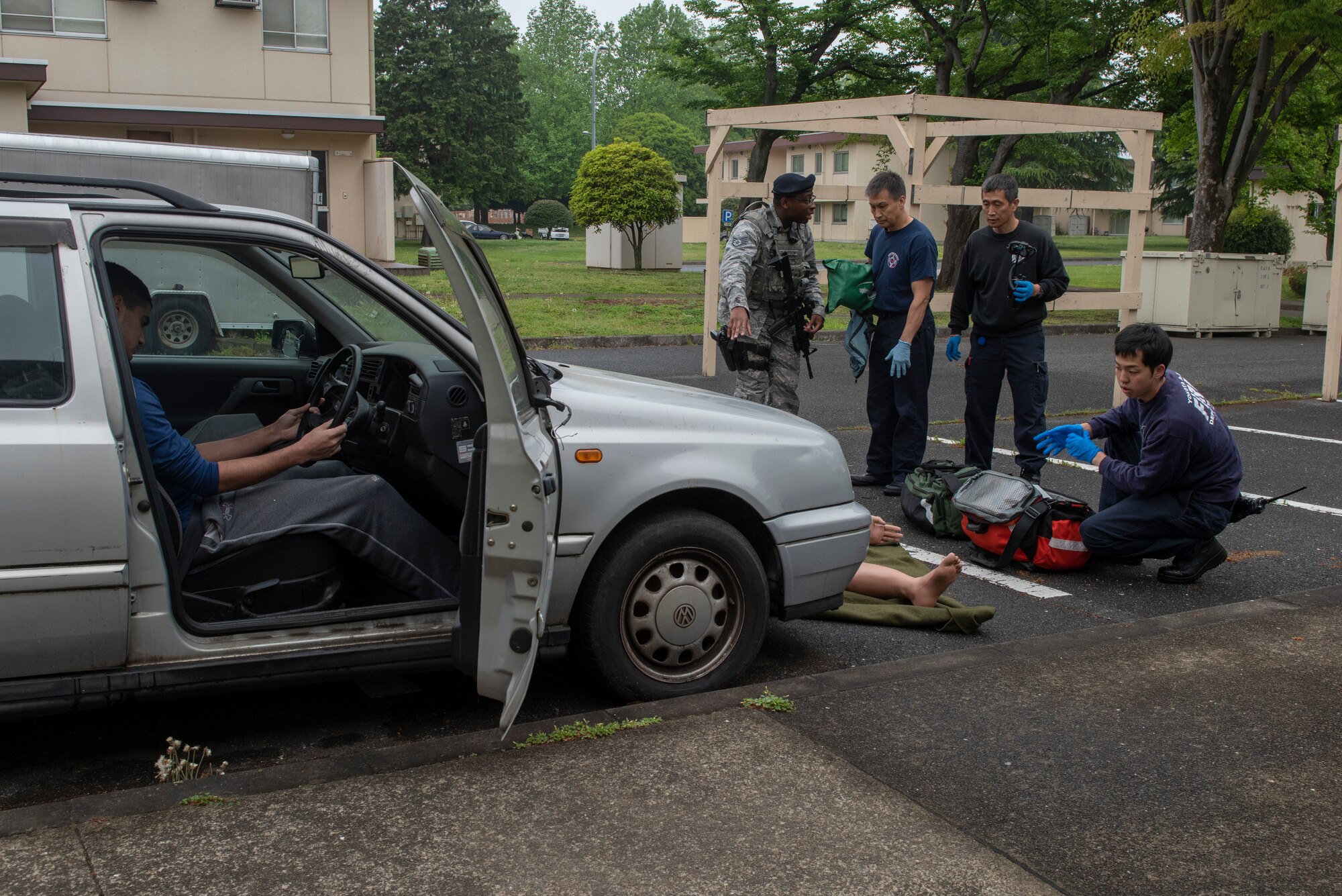 Staff Sgt. Frederick Thompson, 374th Security Forces Squadron patrolman, explains the situation to the first responders from the 374th Civil Engineer Squadron during an inter-agency emergency medical response exercise at Yokota Air Base, Japan, April 24, 2018.