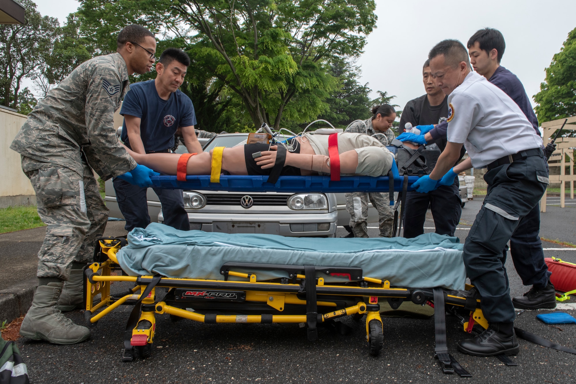 A team of first responders lowers a patient onto a gurney during an inter-agency emergency medical response exercise at Yokota Air Base, Japan, April 24, 2018.