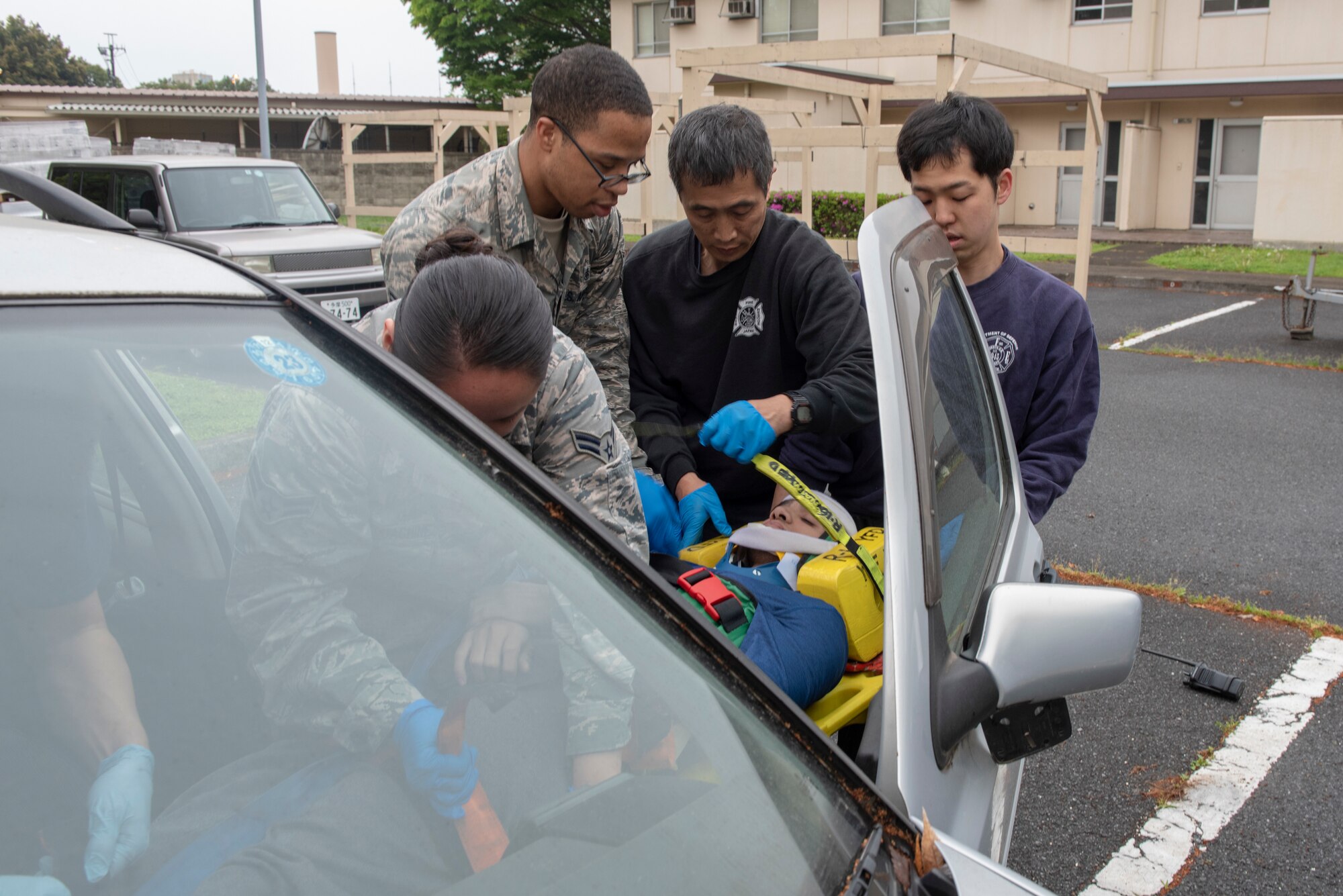 A team of first responders secure a patient to a spine board for extraction during an inter-agency emergency medical response exercise at Yokota Air Base, Japan, April 24, 2018.
