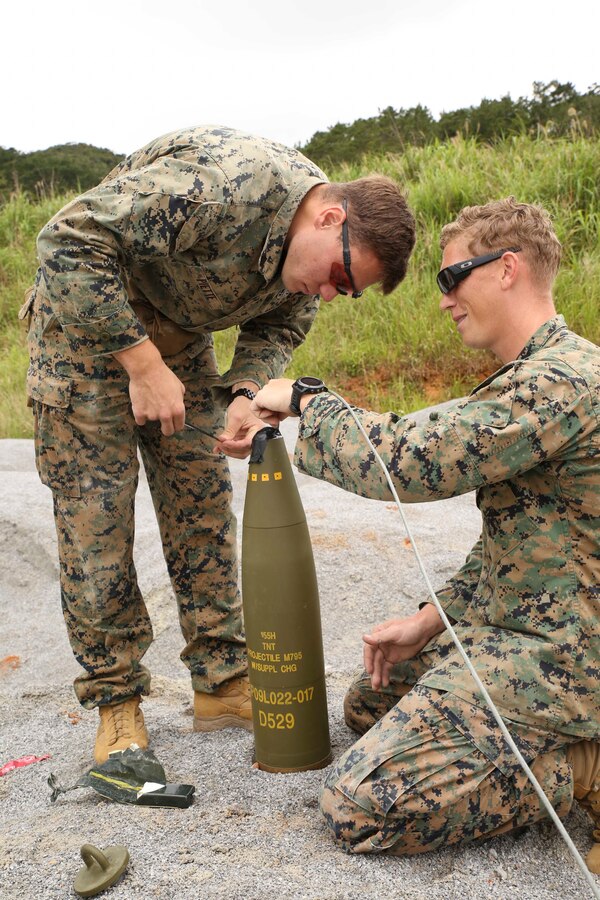 Sgt. Christopher Piette and Staff Sgt. Joshua Firth, explosive ordinance disposal technicians with EOD Company, 9th Engineer Support Battalion, Combat Logistics Regiment 35, set up a 155mm Howitzer round for detonation during post-blast analysis training April 25, 2018 at Camp Hansen, Okinawa, Japan. Marines with EOD Company, 9th ESB and Air Force EOD technicians with EOD Unit, 18th Civil Engineers conducted the training to instruct junior technicians on safe disposal of ordnance and examination of ordinance blast craters to determine potential locations for hostile enemy positions. Piette is a native of Green Bay, Wisconsin and Firth is a native of Seaside, Oregon. (U.S. Marine Corps photo by Sgt. Tiffany Edwards)