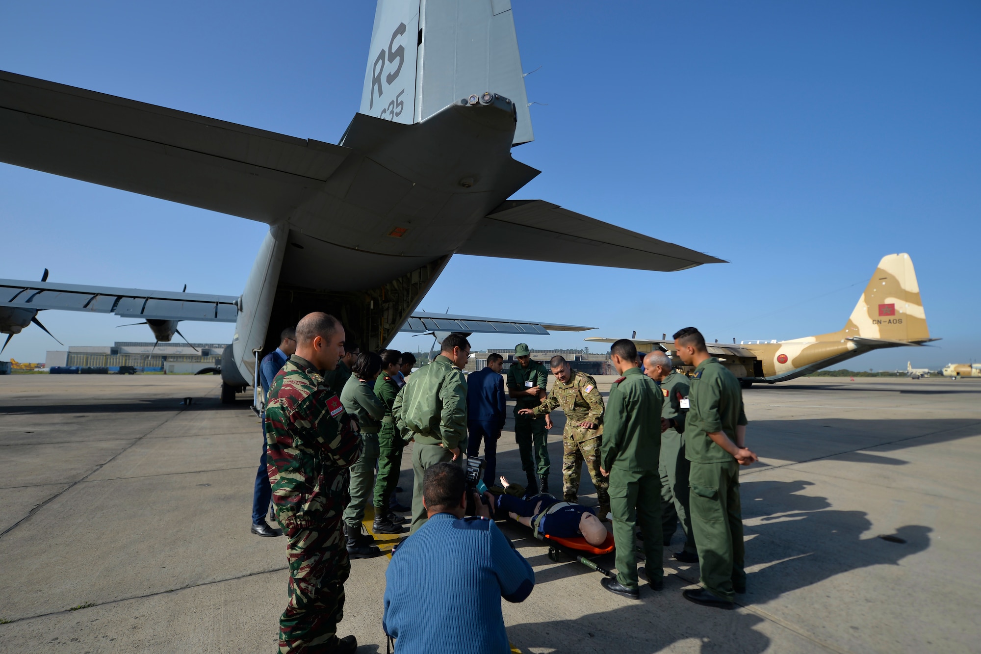 Captain Diego Torres, the 86th Aeromedical Evacuation Squadron flight nurse instructor, center, speaks to Moroccan Royal Armed Forces service members about AE procedures during Exercise African Lion 2018, April 19, 2018, at Kenitra Air Base, Morocco. Airmen from the 86th Aeromedical Evacuation Squadron shared AE procedures with Moroccan Royal Armed Forces service members to promote interoperability of forces. (U.S. Air Force photo by Staff Sgt. Nesha Humes Stanton/Released)