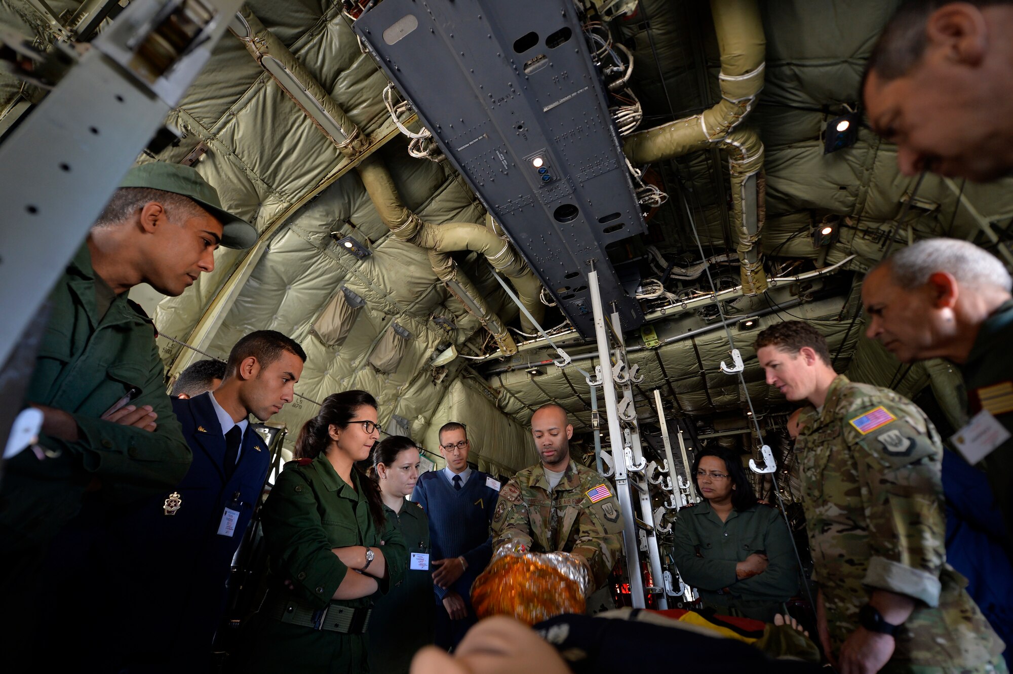 U.S. Air Force Senior Airman Kyle Pacheco, 86th Aeromedical Evacuation Squadron AE technician, center, demonstrates use of an emergency passenger oxygen system during Exercise African Lion 2018, April 19, 2018, at Kenitra Air Base, Morocco. Service members from the Moroccan Royal Armed Forces observed and practiced AE procedures to further develop one another’s capabilities, allowing both nations to operate more efficiently in the event of a contingency operation. (U.S. Air Force photo by Staff Sgt. Nesha Humes Stanton)