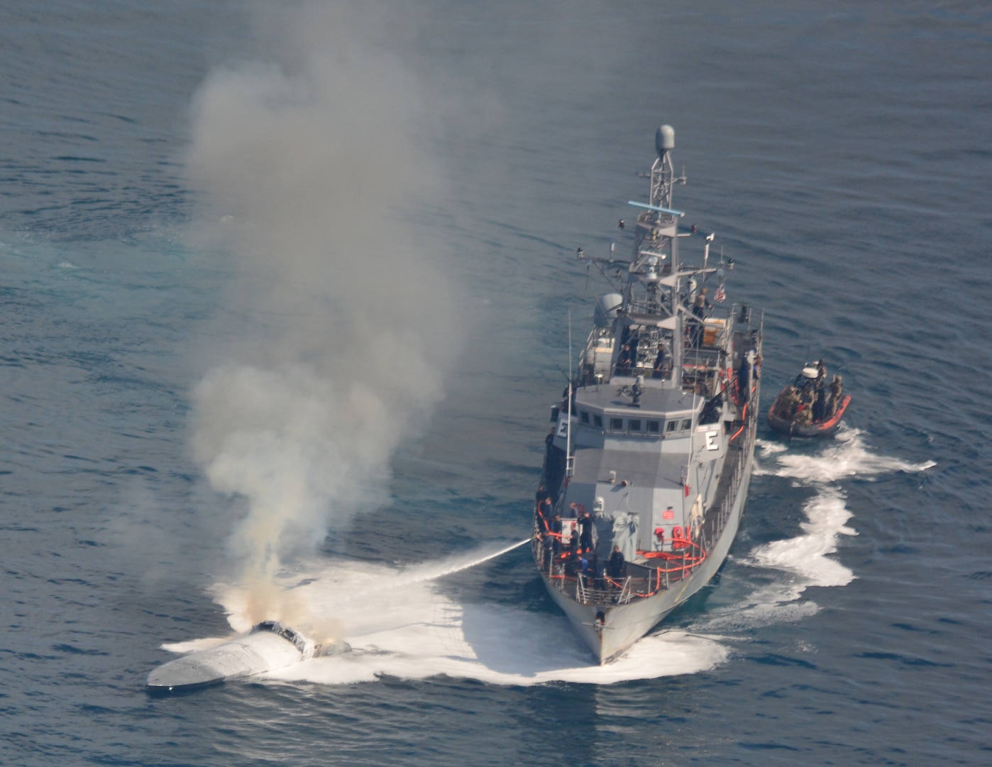 USS Zephyr conducts ship-to-ship firefighting to extinguish a fire aboard a low-profile go-fast vessel.