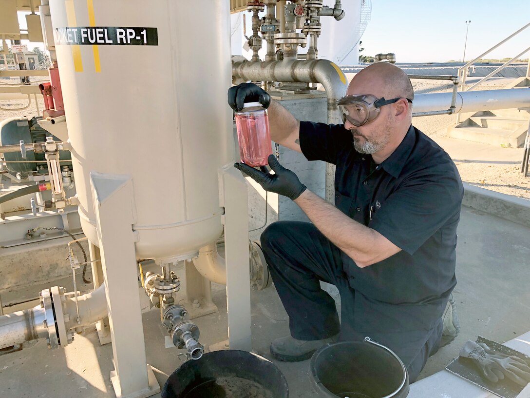 A DLA Energy Aerospace Energy contractor pulls a sample of rocket fuel out of the tank at Vandenberg Air Force Base, California, to send to the Air Force Petroleum Office’s fuel laboratory for testing.