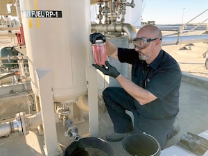 A DLA Energy Aerospace Energy contractor pulls a sample of rocket fuel out of the tank at Vandenberg Air Force Base, California, to send to the Air Force Petroleum Office’s fuel laboratory for testing.