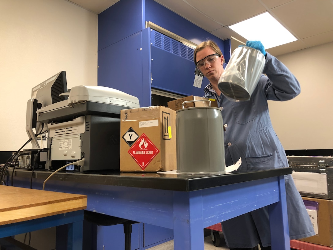 Ainsley Allen, lab chief for the Air Force Petroleum Office’s fuel laboratory at Vandenberg Air Force Base, California, receives samples for testing. The lab tests propellants and gases used on the rockets and analyzes them for contaminants and particles that could interfere with spacecraft operations.