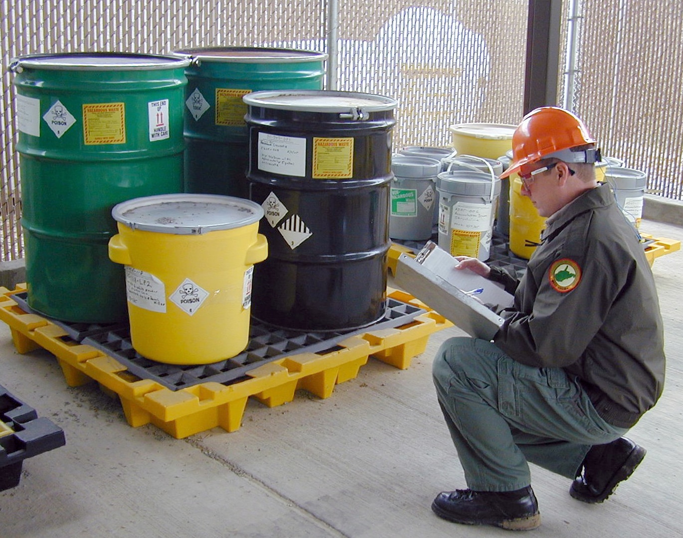 A DLA contractor prepares for the removal of hazardous waste to be removed from a DoD generator site.