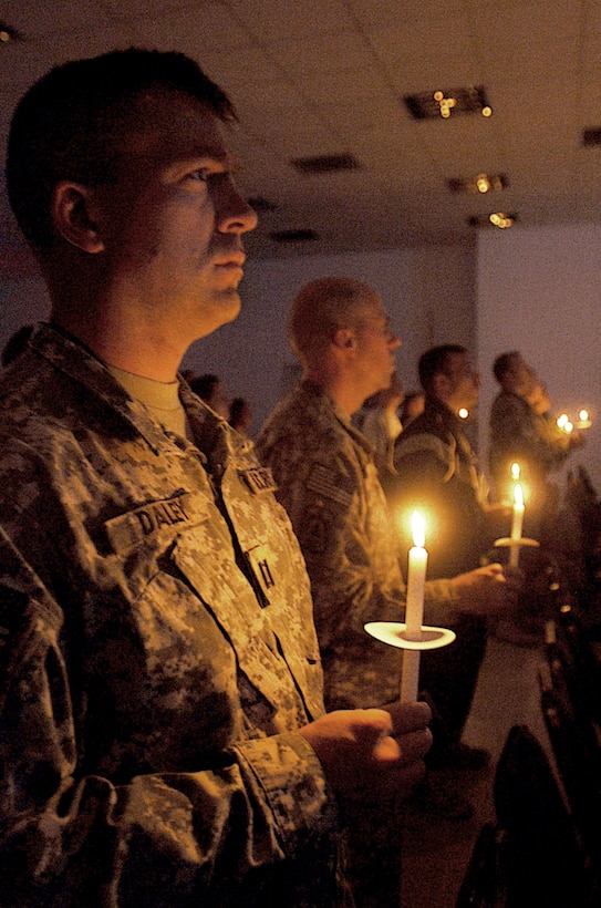 Army Capt. Jeffrey Daley and other service members celebrate Christmas Eve during a candlelight service in Gilbert Memorial Chapel at Joint Base Balad, Iraq. Daley is the officer in charge of administrative support for the 51st Expeditionary Signal Battalion, which is deployed from Fort Lewis, Washington.