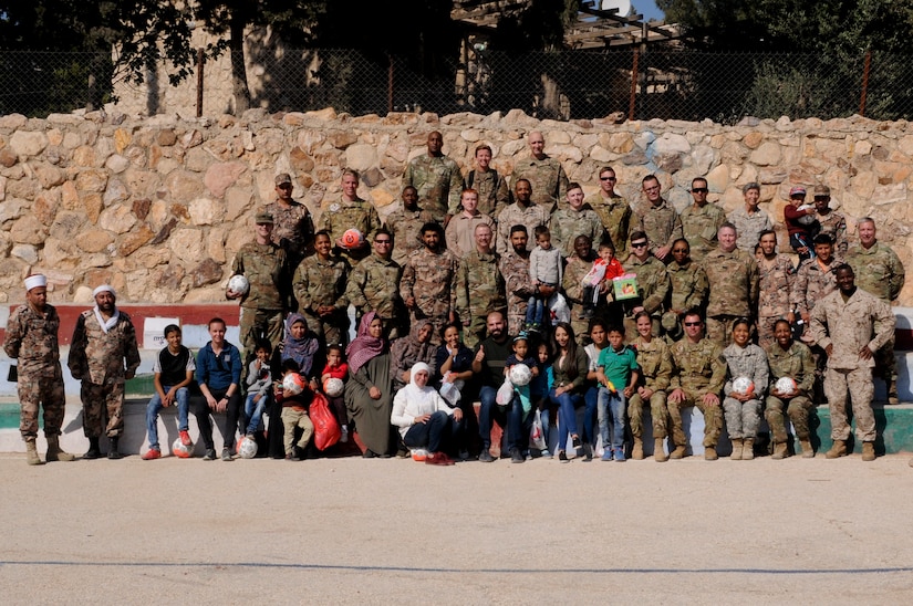 Members of the U.S. military and Jordan Armed Forces pose with workers, relatives and of residents of the Amman SOS Children’s Village April 23. They were all part was part of a donation visit to the village that was arranged by Jordan Armed Forces Imams in coordination with U.S. Chaplains as part of ongoing coordination between the two partner nation militaries. Events like these help to build trust between service members and citizens of different nations.
