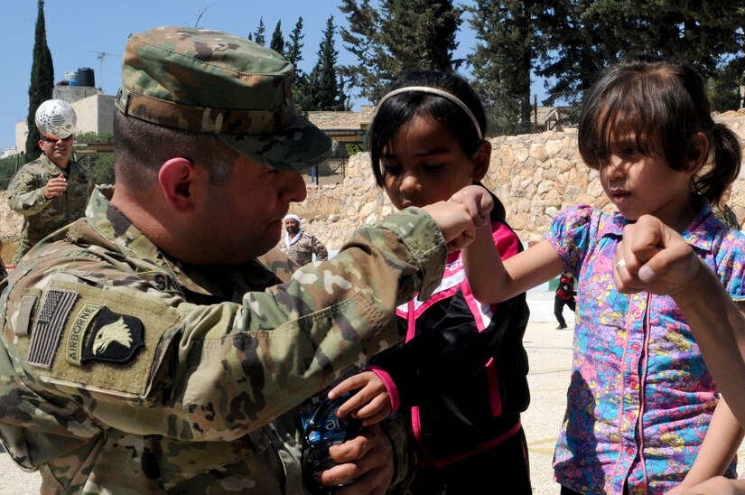 U.S. Army Maj. John Salazar, an information operations officer with U.S. Army Central teaches a resident of the Amman SOS Children’s Village how to do a fist bump April 23. Salazar was part of a donation visit to the village that was arranged by Jordan Armed Forces Imams in coordination with U.S. Chaplains as part of ongoing coordination between the two partner nation militaries. Events like these help to build trust between service members and citizens of different nations.