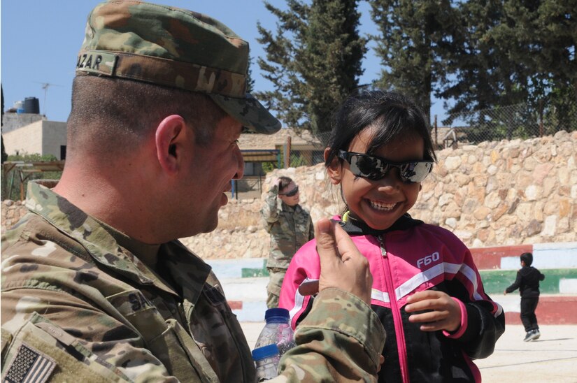 U.S. Army Maj. John Salazar, an information operations officer with U.S. Army Central lets a resident of the Amman SOS Children’s Village try on his sunglasses  April 23. Salazar was part of a donation visit to the village that was arranged by Jordan Armed Forces Imams in coordination with U.S. Chaplains as part of ongoing coordination between the two partner nation militaries. Events like these help to build trust between service members and citizens of different nations.