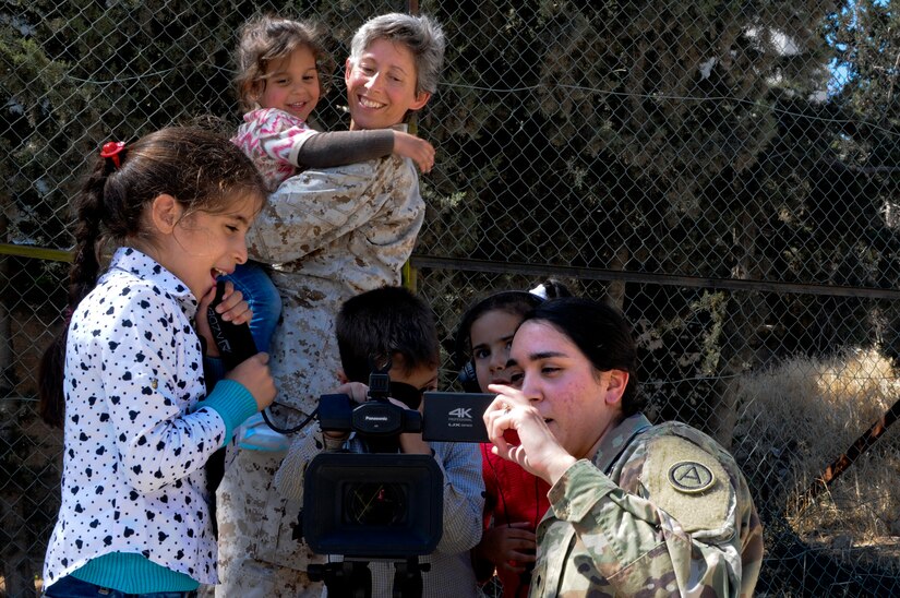 U.S. Army Spc. Nicholle Salvatierra, a public affairs broadcast specialist with U.S. Army Central, shows residents of the Amman SOS Children’s Village how her video camera works as U.S. Navy Chaplain (Lt. Cmdr.) Victoria Chappell, Naval Amphibious Forces, Task Force 51 and 5th Marine Expeditionary Forces Brigade looks on April 23. They were part of a donation visit to the village that was arranged by Jordan Armed Forces Imams in coordination with U.S. Chaplains as part of ongoing coordination between the two partner nation militaries. Events like these help to build trust between service members and citizens of different nations.