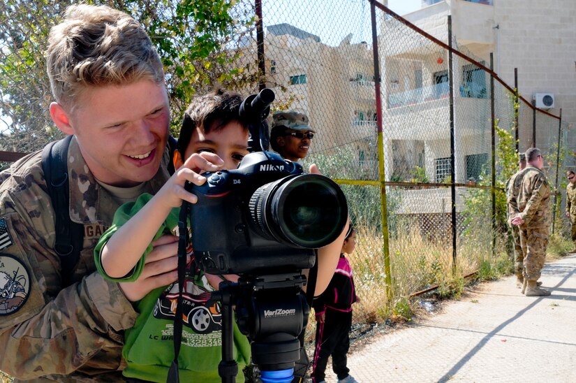 A U.S. Soldier shows a resident of the Amman SOS Children’s Village how to use his camera April 23. The Soldier was part of a donation visit to the village that was arranged by Jordan Armed Forces Imams in coordination with U.S. Chaplains as part of ongoing coordination between the two partner nation militaries. Events like these help to build trust between service members and citizens of different nations.