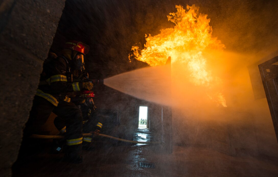 Col. Christopher Bromen, 423rd Air Base Group commander, hoses out a fire during a 423rd Civil Engineering Squadron active fire training event at RAF Molesworth, England, April 23, 2018. During the training, Bromen had the opportunity to train with firefighters and observe their specialized skills. (U.S. Air Force photo by Tech. Sgt. Brian Kimball)