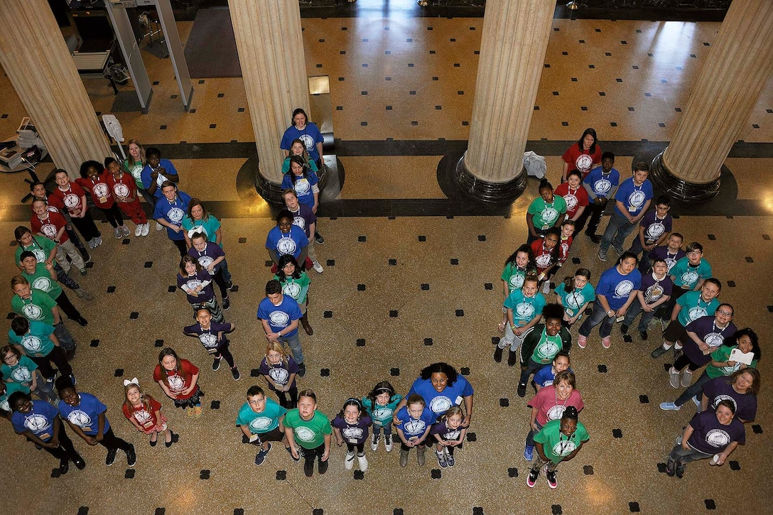 Children participating in Bring Your Child to Work Day line up to spell D-L-A as they spend a day learning about the Defense Logistics Agency and protecting themselves.