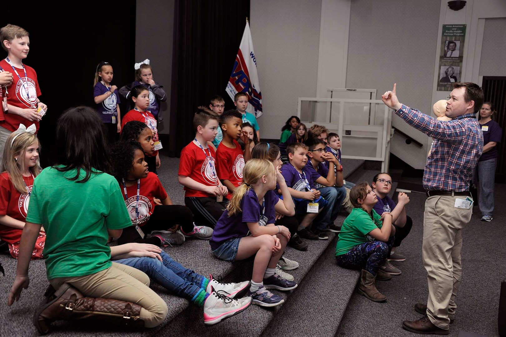 Medical Response Team Leader Adam Beam instructs children participating in Bring Your Child to Work Day about some basic first aid techniques.