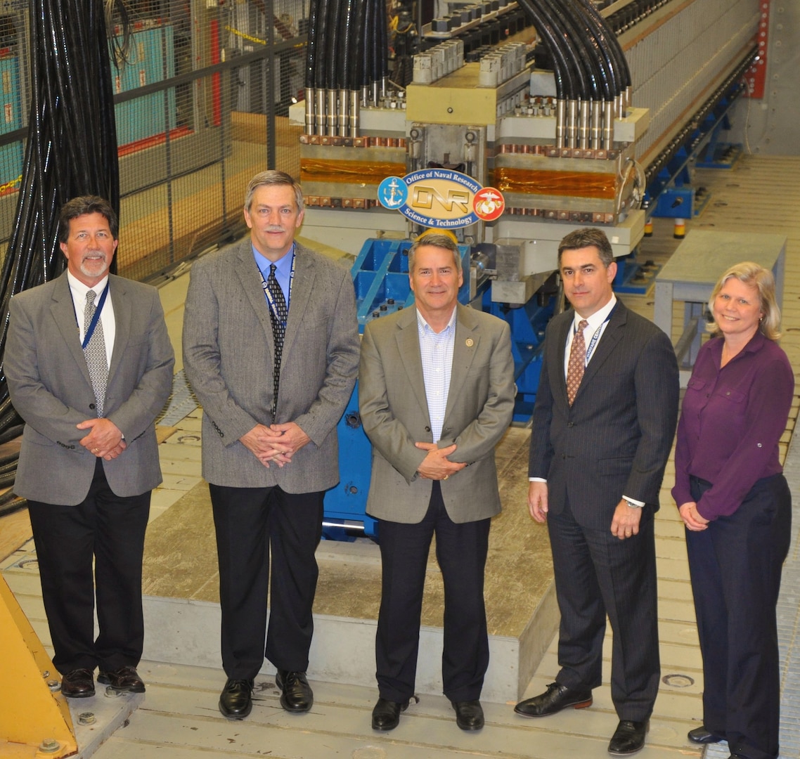 IMAGE: DAHLGREN, Va. (April 24, 2018) - U.S. Rep. Jody Hice, (R-Ga.) is pictured with Naval Surface Warfare Center Dahlgren Division (NSWCDD) leaders in front of the Navy's electromagnetic railgun laboratory launcher. The congressman - who was briefed by NSWCDD engineers on electromagnetic launchers and hypervelocity projectiles - observed the launcher fire a projectile in a demonstration. Hice also watched a laser weapon demonstrated during briefings on directed energy weapons and development. Throughout his tour of NSWCDD facilities, Hice saw the command's capability to develop and integrate complex warfare systems, including the ability to incorporate electric weapons technology into existing and future fighting forces and platforms. Standing left to right: Stephen Malyevac, NSWCDD distinguished scientist for surface engagement; Chester Petry, NSWCDD electromagnetic railgun lead systems engineer; U.S. Rep. Jody Hice; Dale Sisson, NSWCDD deputy technical director; and Stephanie Hornbaker, NSWCDD Gun and Electric Weapon Systems department head.  (U.S. Navy photo by John Joyce/Released)