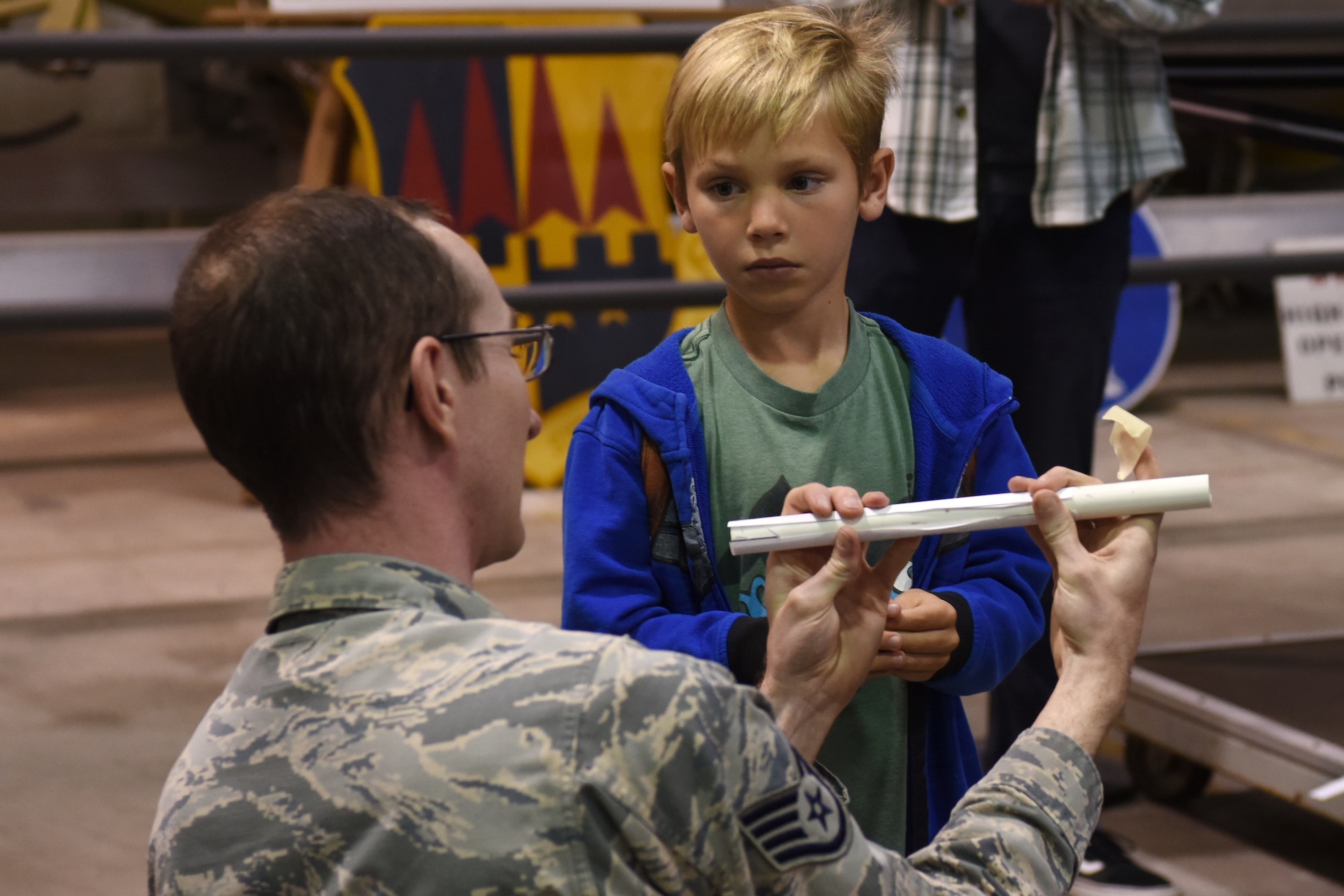 Staff Sgt. Stefan McKinley, 4th Space Launch Squadron mission assurance technician, shows children how to build their own model rocket during Bring Your Child to Work Day April 26, 2018, Vandenberg Air Force Base, Calif. McKinley explained the importance of engineering choices while building a model rocket. (U.S. Air Force photo by Airman Aubree Milks/Released)