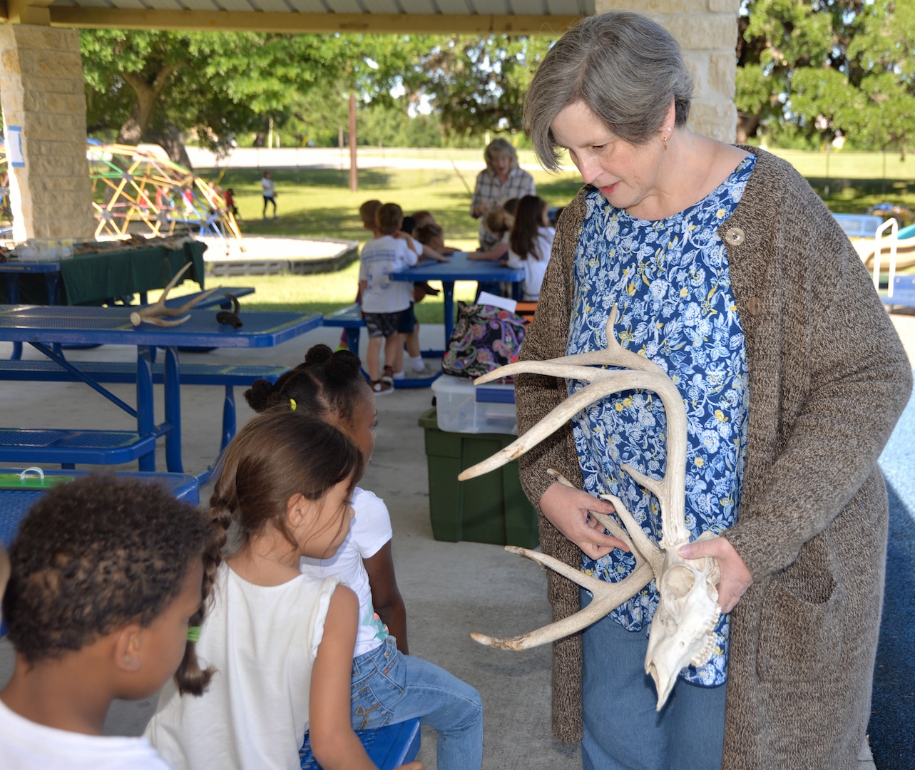 Cathy Kropp, U.S. Army Environmental Command environmental public affairs specialist, shows deer antlers to students from Fort Sam Houston Elementary School during a nature field put on by the command at Salado Park, at Joint Base San Antonio-Fort Sam Houston, April 26.