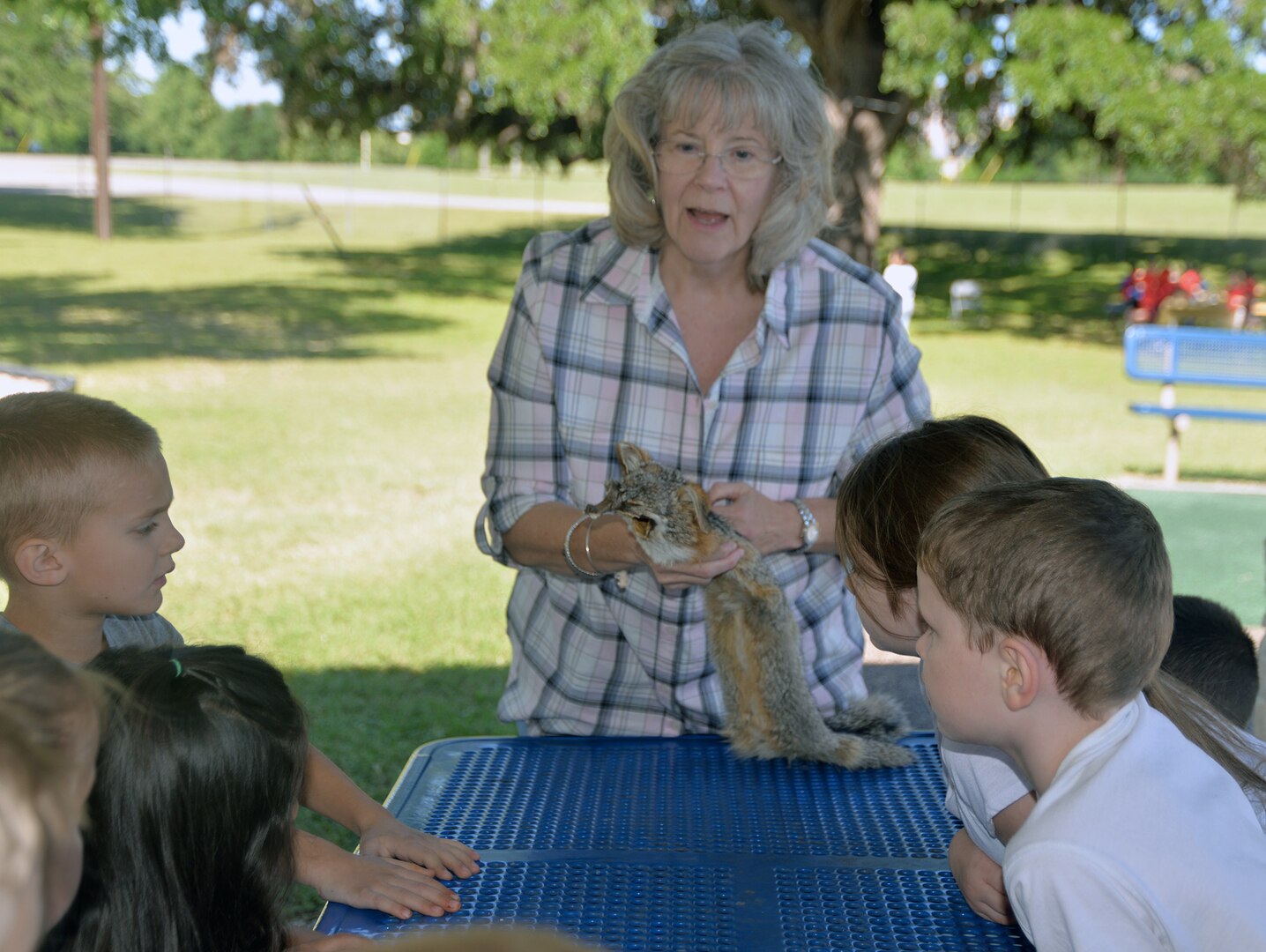 Ann Wood, U.S. Army Environmental Command West Division chief, shows a fox skin to students from Fort Sam Houston Elementary School during a nature field trip put on by the command at Salado Park, at Joint Base San Antonio-Fort Sam Houston, April 26.