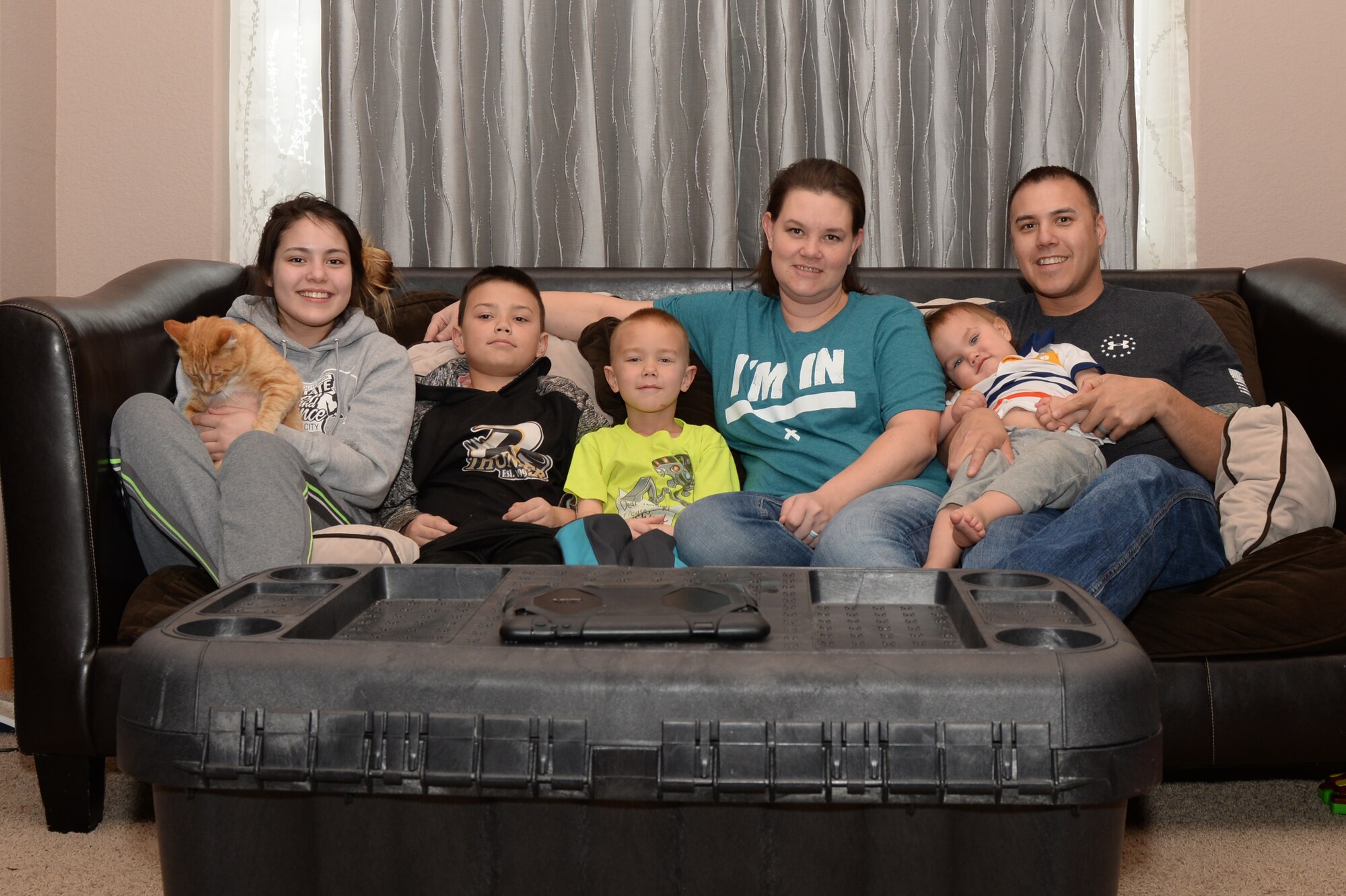 Tech. Sgt. Brian Thomas, the 28th Civil Engineer Squadron noncommissioned officer in charge of power production,  and Tech. Sgt. Leah Thomas, noncommissioned officer in charge of Quality Assurance, Aircrew Flight Equipment, sit for a family photo at their home in Box Elder, S.D., April 19, 2018. Brian and Leah have been foster parents for more than four years and have housed over 40 children. (U.S. Air Force photo by Airman 1st Class Nicolas Z. Erwin)