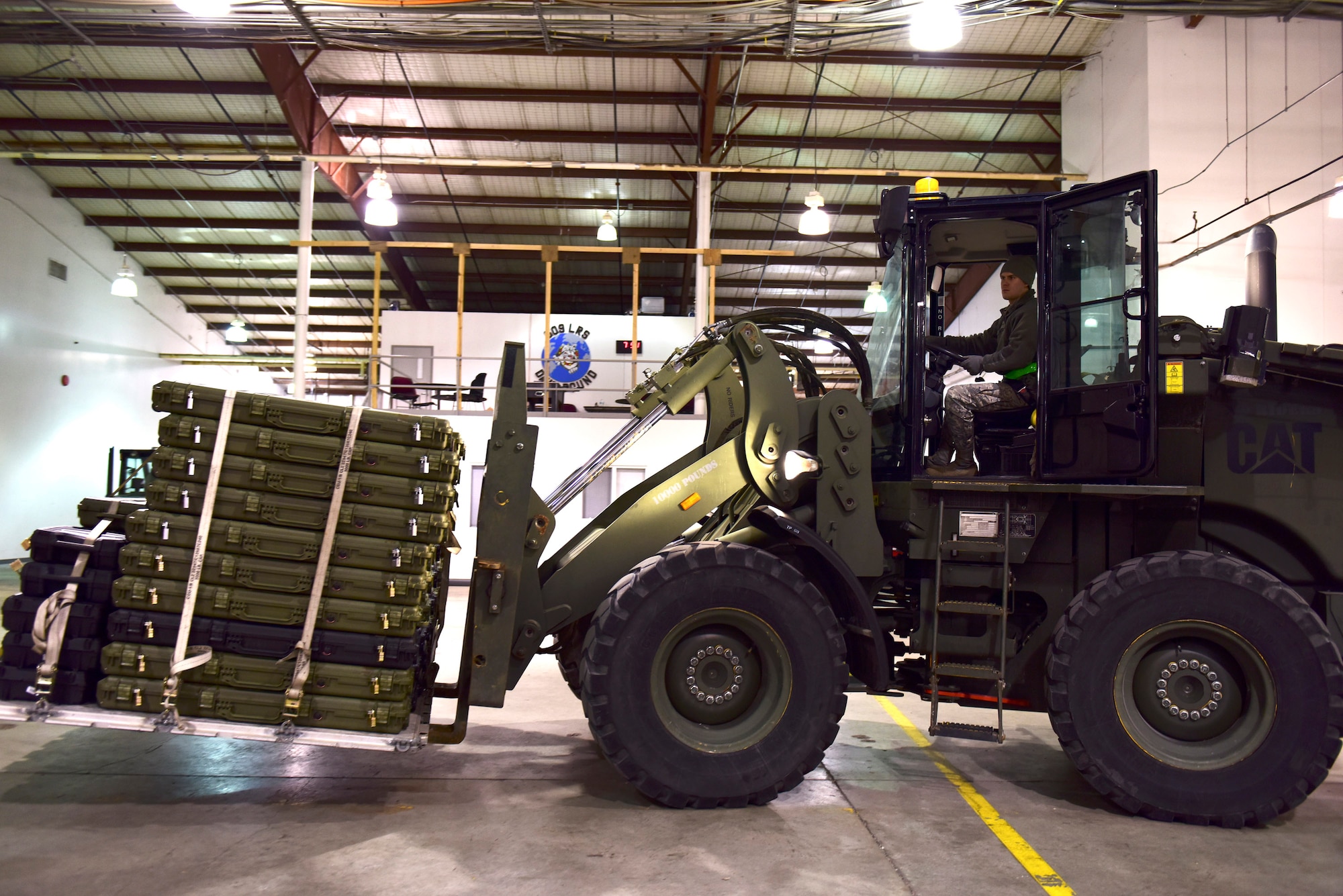 U.S. Air Force Airman 1st Class Tyler Neff, a member of the 509th Logistics Readiness Squadron, transfers weapons with a 10K-AT forklift driver at Whiteman Air Force Base, Mo., Jan. 13, 2018, in support of a 442d Fighter Wing deployment. The 509th and 131st work together to ensure missions, such as deployments and humanitarian efforts, are successful. (U.S. Air Force photo by Staff Sgt. Danielle Quilla)